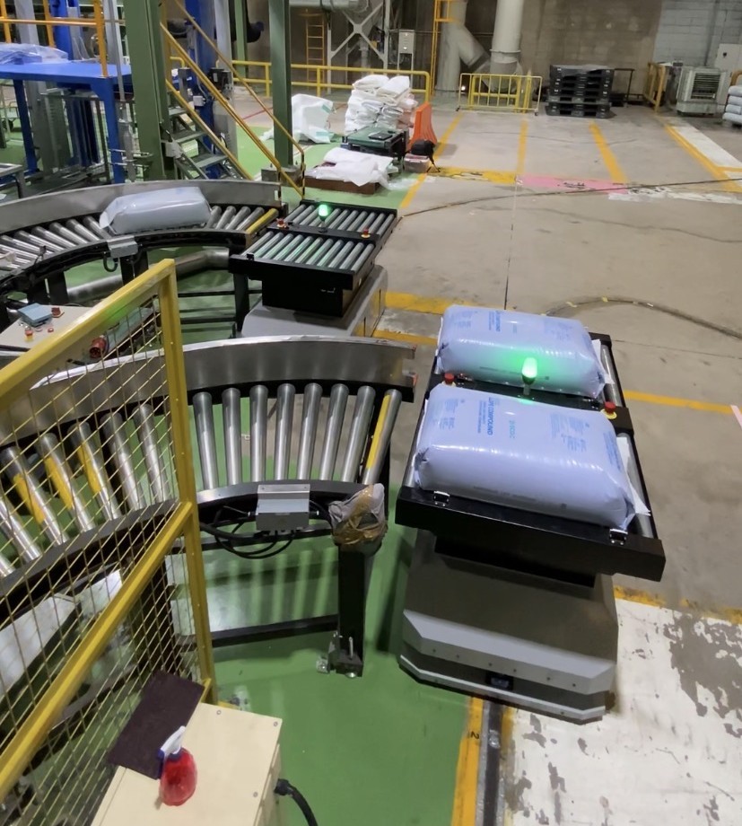 Dual-conveyor AGV routing bags in a plastic manufacturing plant